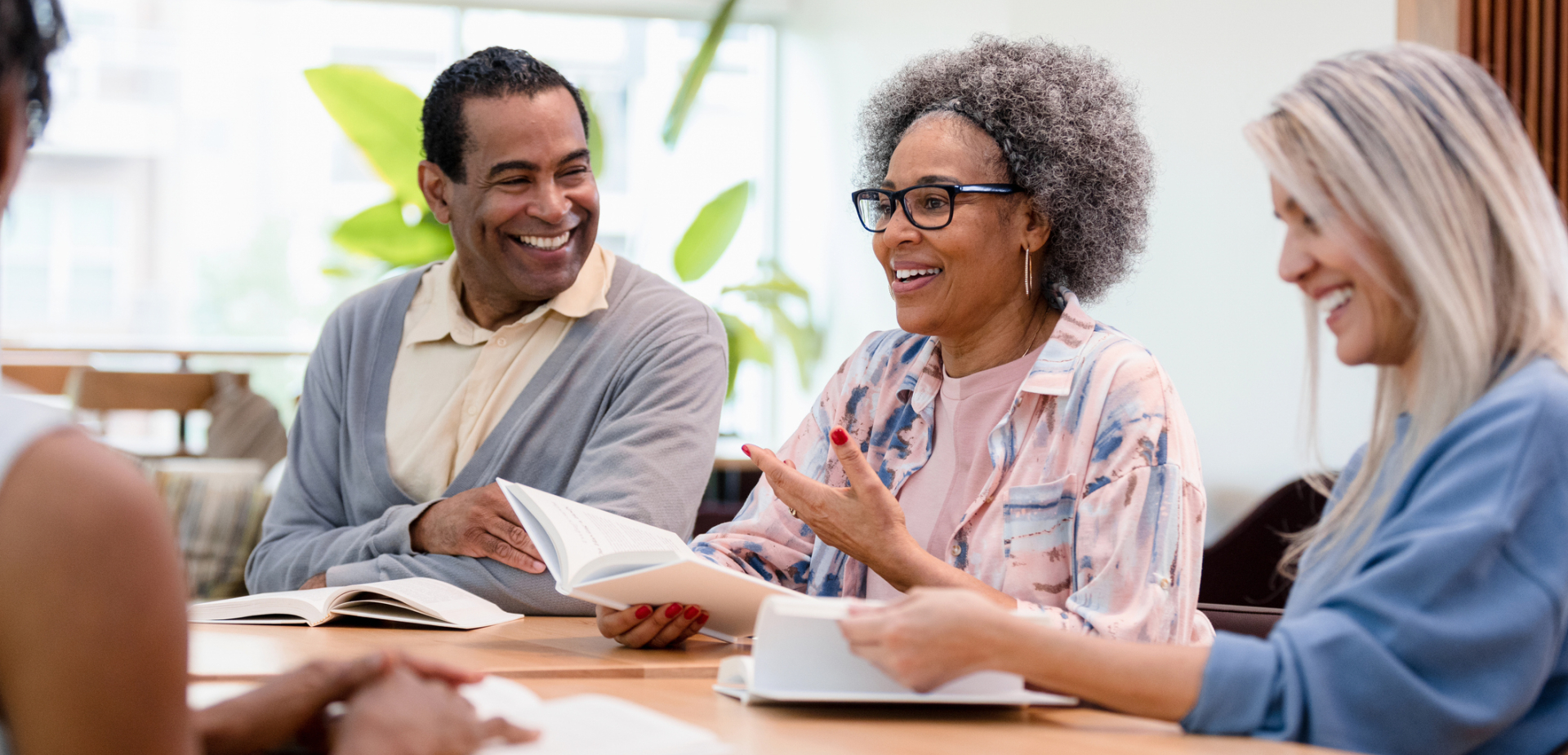 Adults around a table with books in front of them having a discussion